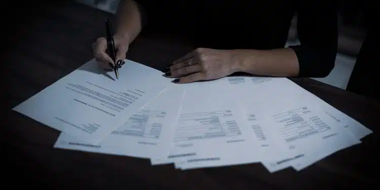 a woman sitting at a table with lots of papers